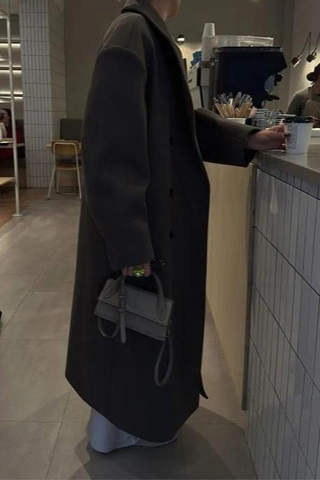Długi brązowy damski płaszcz zimowy, dwurzędowy, elegancki. Must-have w zimowej modzie damskiej.