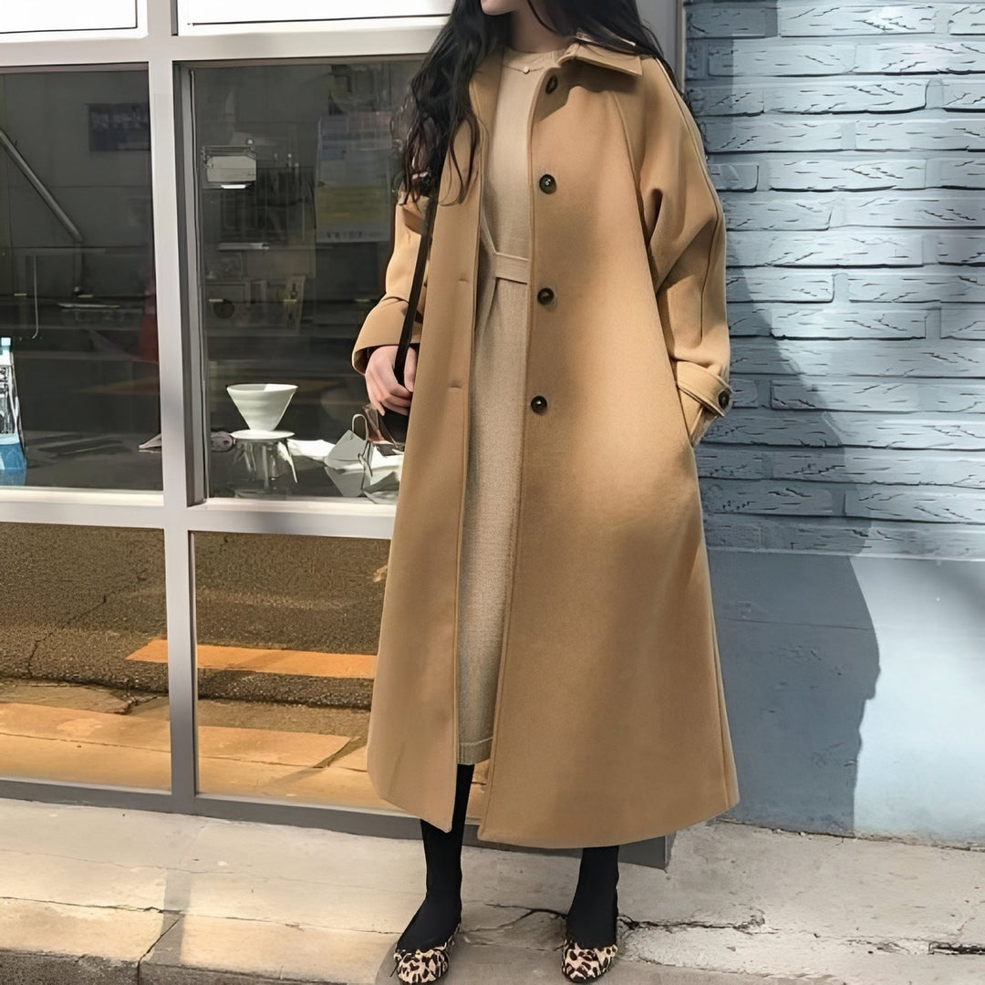 Modny długi płaszcz damski w kolorze khaki. Elegancka odzież wierzchnia na jesień, stylowy wybór.