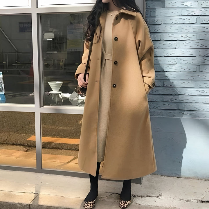Modny długi płaszcz damski w kolorze khaki. Elegancka odzież wierzchnia na jesień, stylowy wybór.