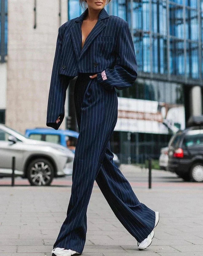 Szerokie spodnie damskiego garnituru w prążki, zapewniające komfort i elegancki look. Moda damska.
