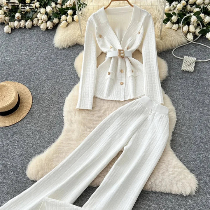 Damski elegancki komplet dzianinowy na modelce. Sweter i spodnie wide leg w jednolitym kolorze. Modny wybór.