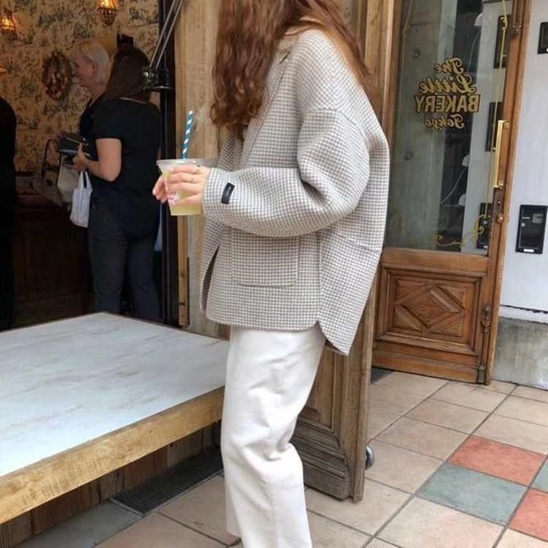 Stylowy krótki płaszcz damski w pepitkę, idealny na wiosnę, podkreślający elegancję i modowy styl.