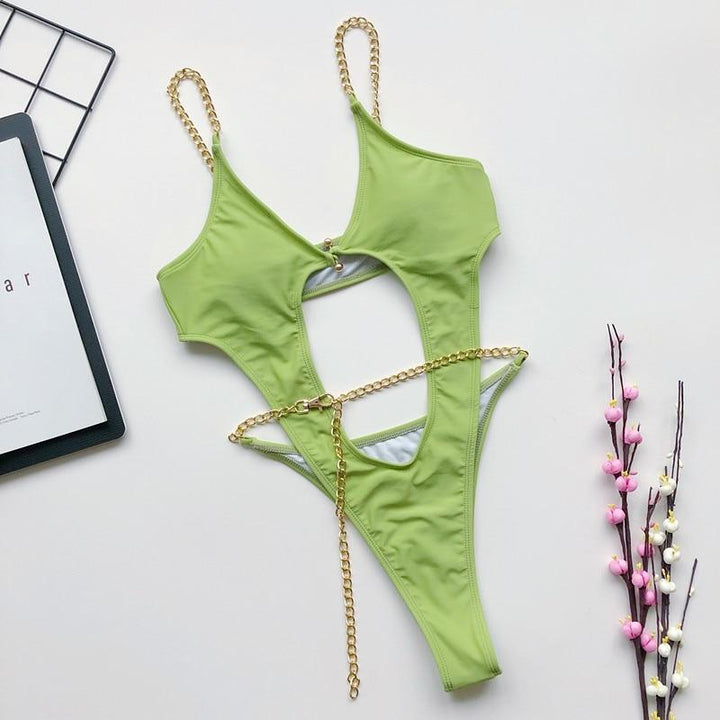 Elegancki damski strój kąpielowy monokini z wycięciami i złotymi łańcuszkami. Idealny na plażę i lato.