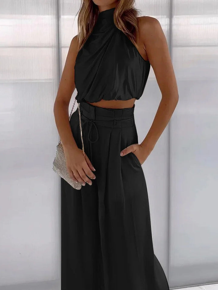 Stylowy komplet damski koktajlowy: elegancki top halter i szerokie spodnie z wysokim stanem.