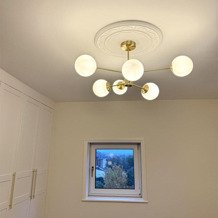 Mosiężny żyrandol Sputnik, opalowe klosze. Elegancka lampa sufitowa do przestrzeni loftowych.