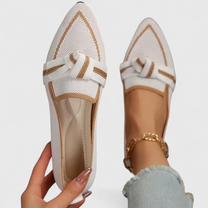 Białe damskie mokasyny slip-on z kokardą prezentowane na stopie
