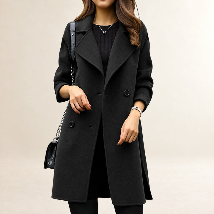 Modelka w eleganckim czarnym płaszczu dwurzędowym z torebką