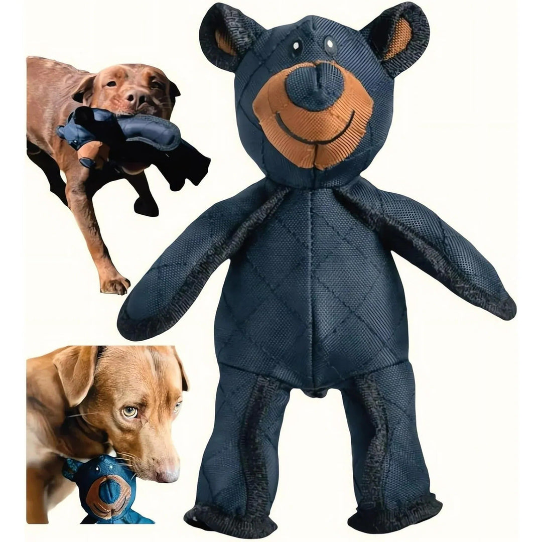 Brązowy pies rasy labrador trzymający w pyszczku niebieskiego misia-zabawkę obok stojącego modelu