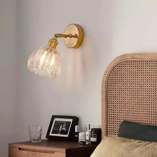 Zbliżenie na szklany klosz tulipan kinkietu ściennego retro. Detal lampy vintage, idealny do sypialni.