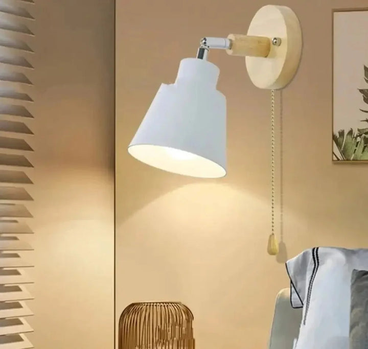 Biała lampa ścienna w stylu skandynawskim nad łóżkiem