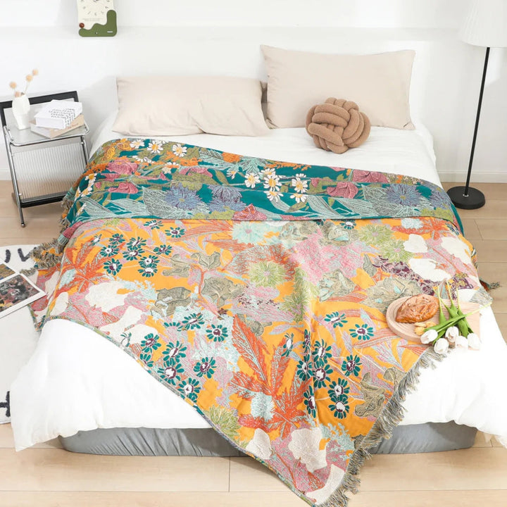 Tekstylny koc patchwork w stylu boho z kolorowymi wzorami kwiatowymi i ozdobnymi frędzlami. Narzuta na łóżko.