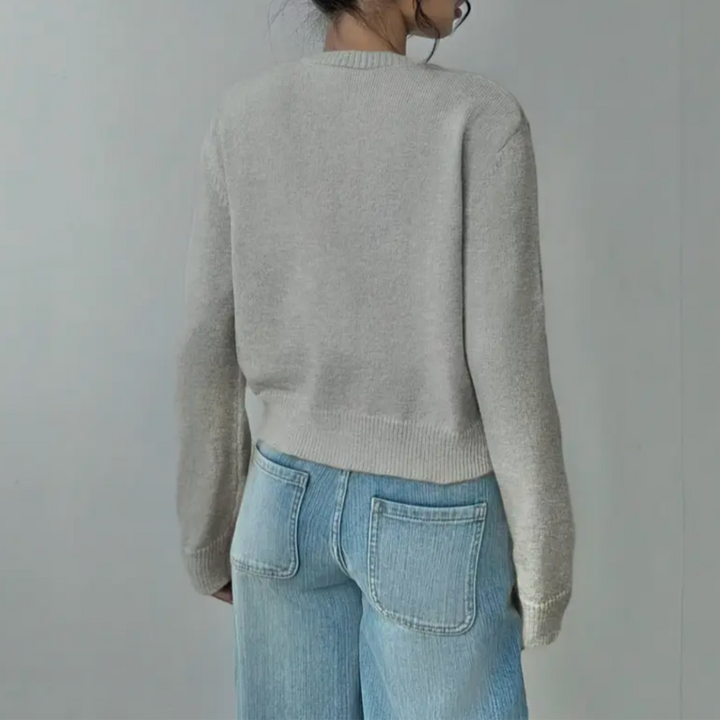 Modny krótki sweter damski zapinany na guziki zaprezentowany na sylwetce