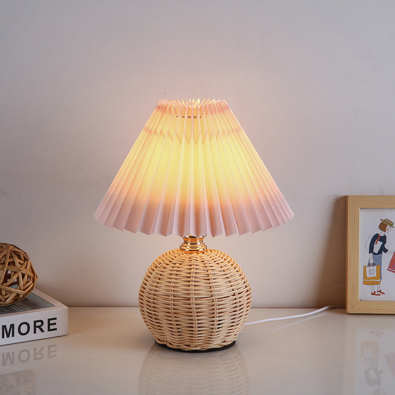Nowoczesna lampa stołowa LED, rattanowa podstawa, plisowany abażur, oświetlenie akcentowe i dekoracja.