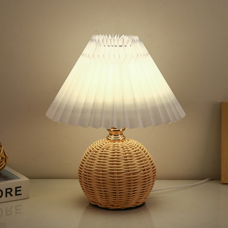 Elegancka lampa stołowa LED z abażurem plisowanym i podstawą z rattanu, idealna do sypialni.