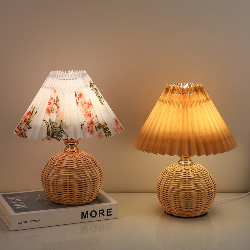 Stylowa lampa stołowa LED, rattanowa podstawa, plisowany abażur, do dekoracji wnętrz i czytania.