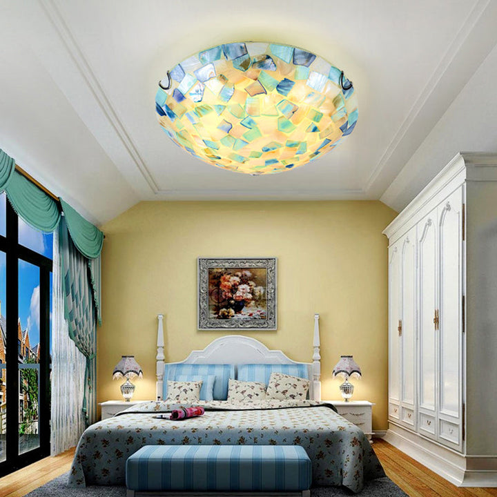 Okrągła lampa sufitowa w stylu Tiffany z niebieskim kloszem w eleganckiej sypialni.