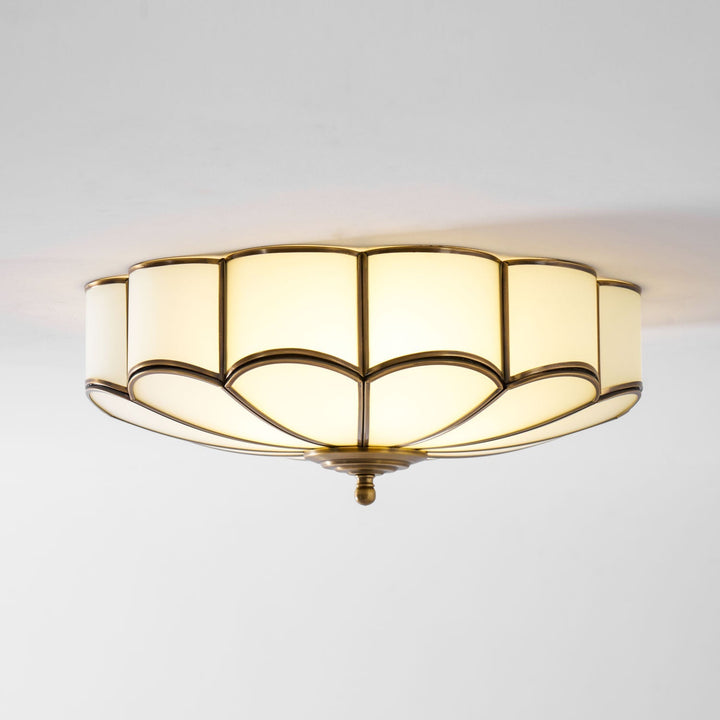 Stylowa lampa wpuszczana, biała oprawa z mosiężnymi kwiatami, nowoczesny wygląd.