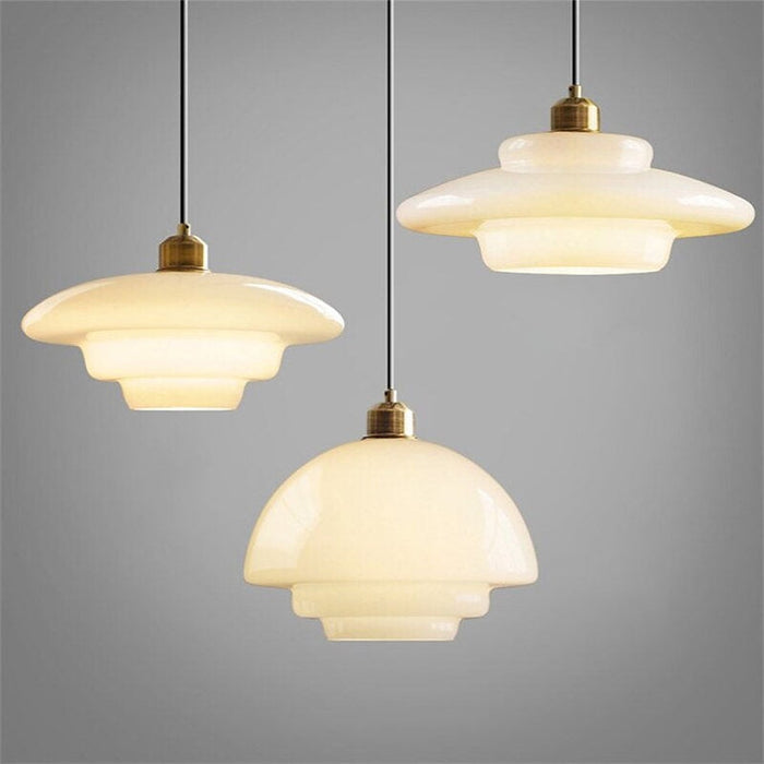 Oświetlenie salonu: klasyczna lampa wisząca, mleczne szkło i mosiądz. Styl retro.