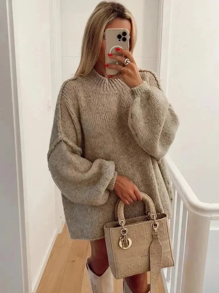 Kobieta w beżowym swetrze oversize trzymająca torebkę