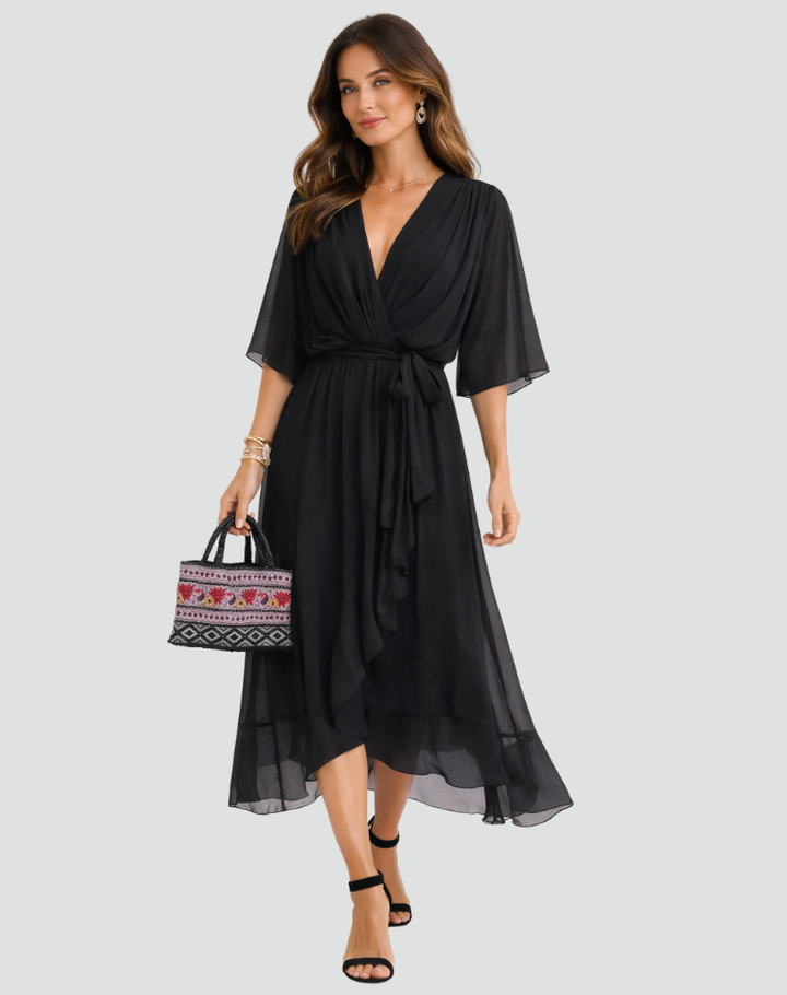 Modelka w eleganckiej czarnej sukience midi z szerokimi rękawami