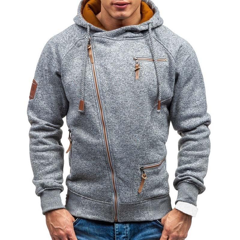 Mężczyzna w stylowej bluzie rozpinanej z kapturem i asymetrycznym zamkiem, prezentujący styl sportowy/casual.