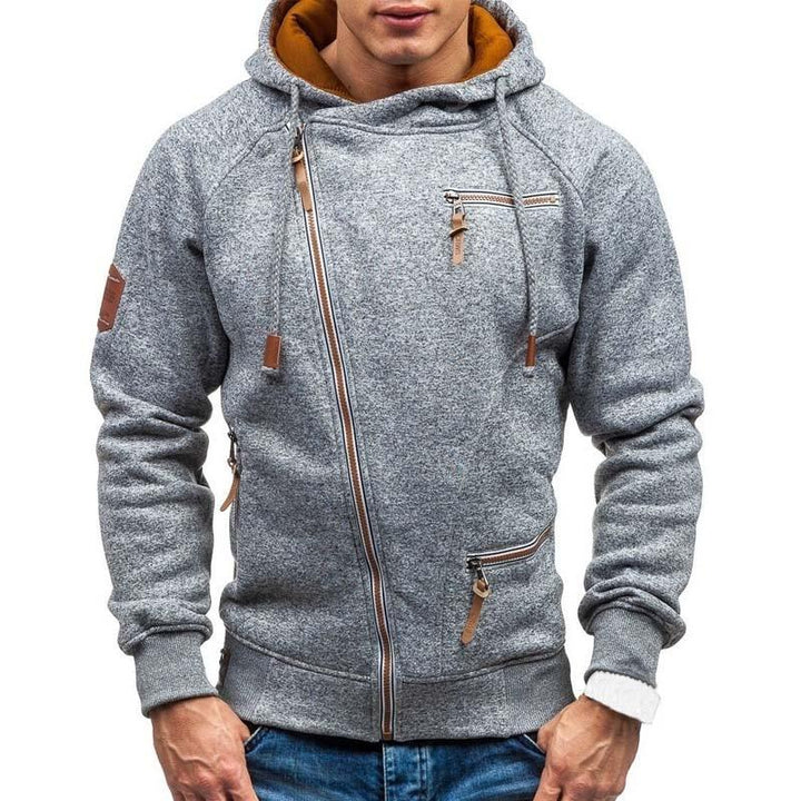 Mężczyzna w stylowej bluzie rozpinanej z kapturem i asymetrycznym zamkiem, prezentujący styl sportowy/casual.