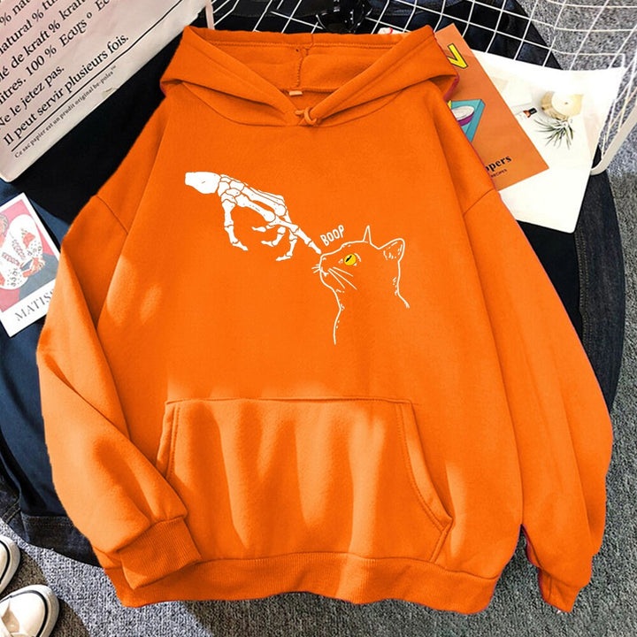 Mężczyzna pozujący w luźnej, modnej bluzie z kapturem i uroczym kotkiem. Styl casual i streetwear.