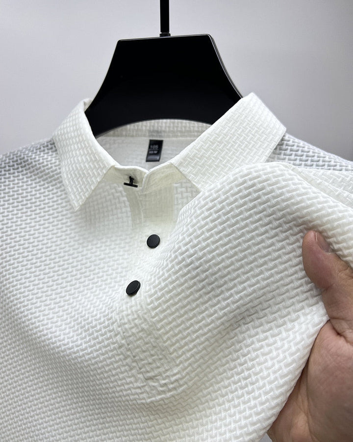 Zbliżenie na przewiewny materiał męskiej koszulki polo, zapewniający komfort i styl w letnie dni.