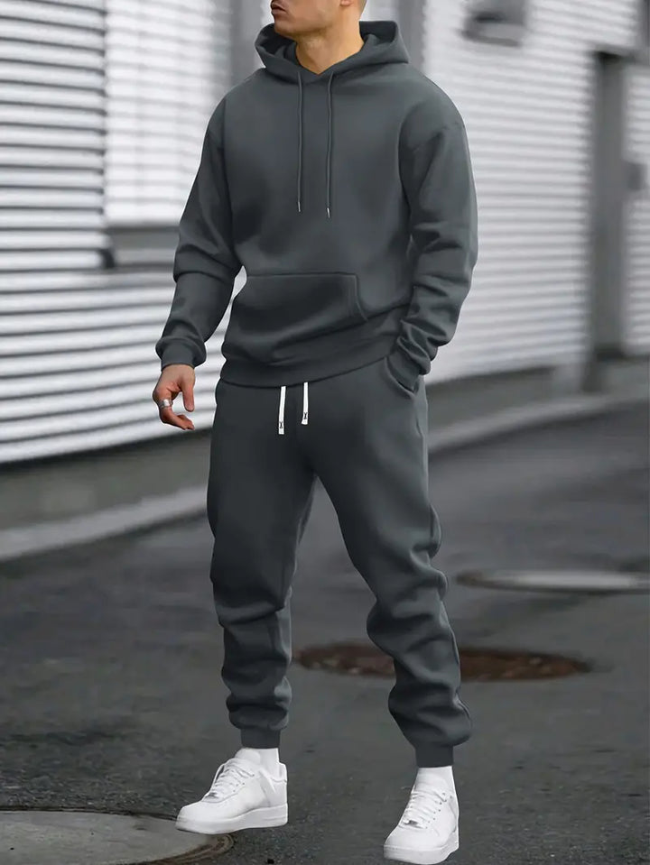 Dresowy komplet męski z miękkiej tkaniny. Bluza z kapturem i spodnie dresowe zapewniają wygodę i sportowy styl.
