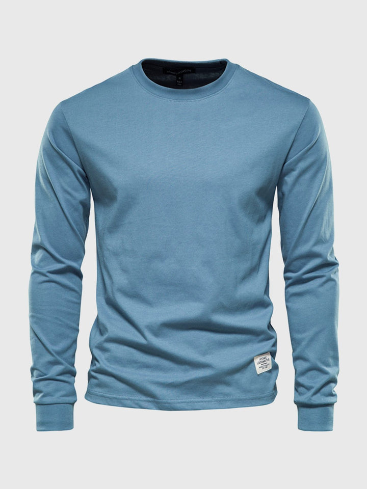 Detal: tekstura gładkiego longsleeve męskiego, koszulka z długim rękawem podkreślająca wygodę i casualowy styl.