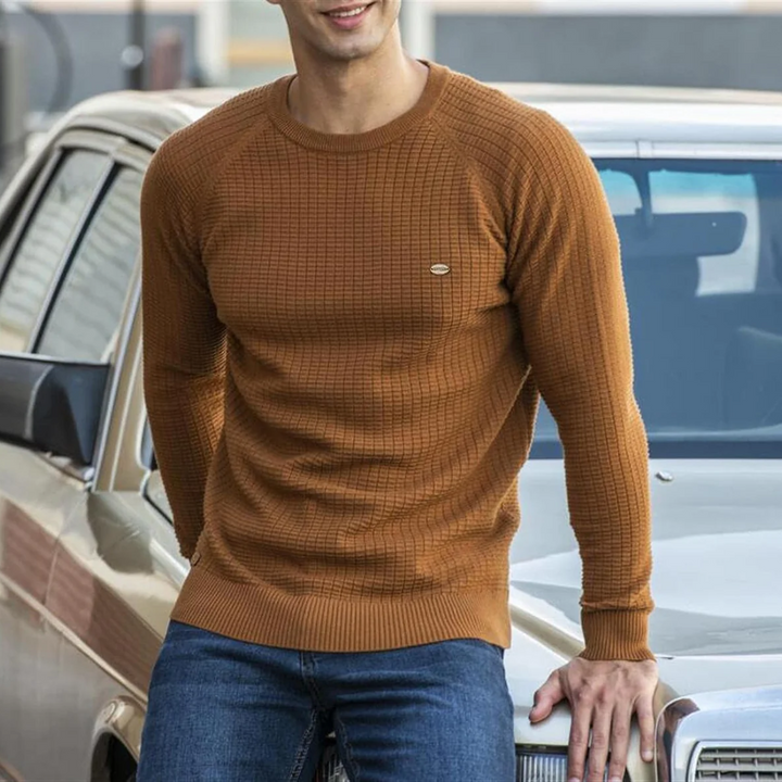 Mężczyzna w eleganckim swetrze z okrągłym dekoltem, demonstrujący casualowy styl męski.