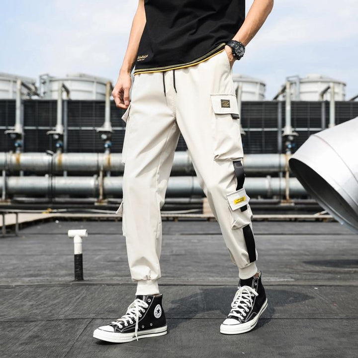 Modne męskie spodnie cargo bojówki z naszywkami. Dopasowany krój, wygoda i streetwearowy styl dla mężczyzn.