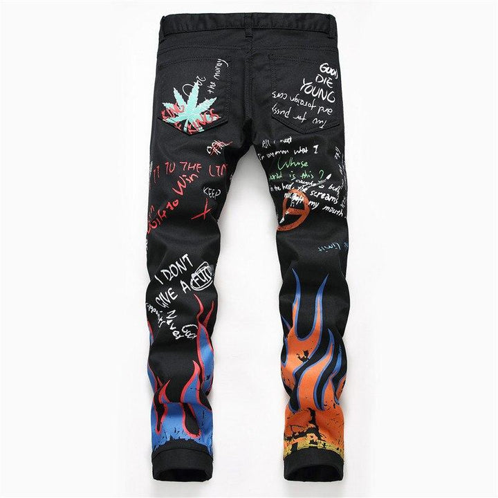 Zbliżenie na unikatowe nadruki na czarnych męskich jeansach slim fit, podkreślające ich modny styl.