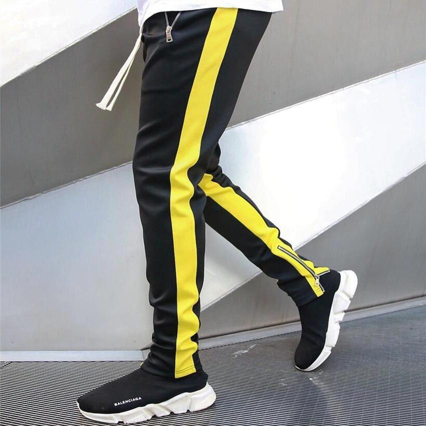 Nowoczesne dwukolorowe spodnie dresowe męskie. Komfortowy krój, sportowy design, modne zamki i rozporki.