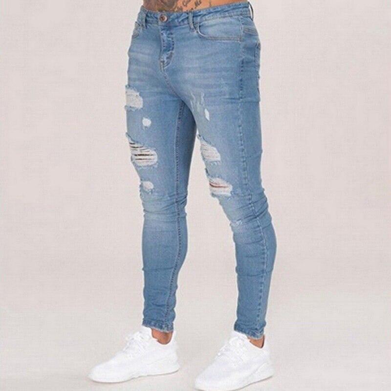 Męskie jeansy slim fit niebieskie z przetarciami, modne i casualowe spodnie dopasowane.