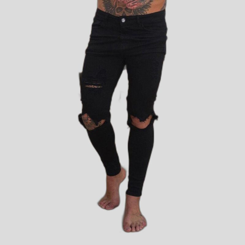 Stylowe męskie jeansy slim fit z efektywnymi dziurami, podkreślające sylwetkę. Modne spodnie męskie na co dzień.