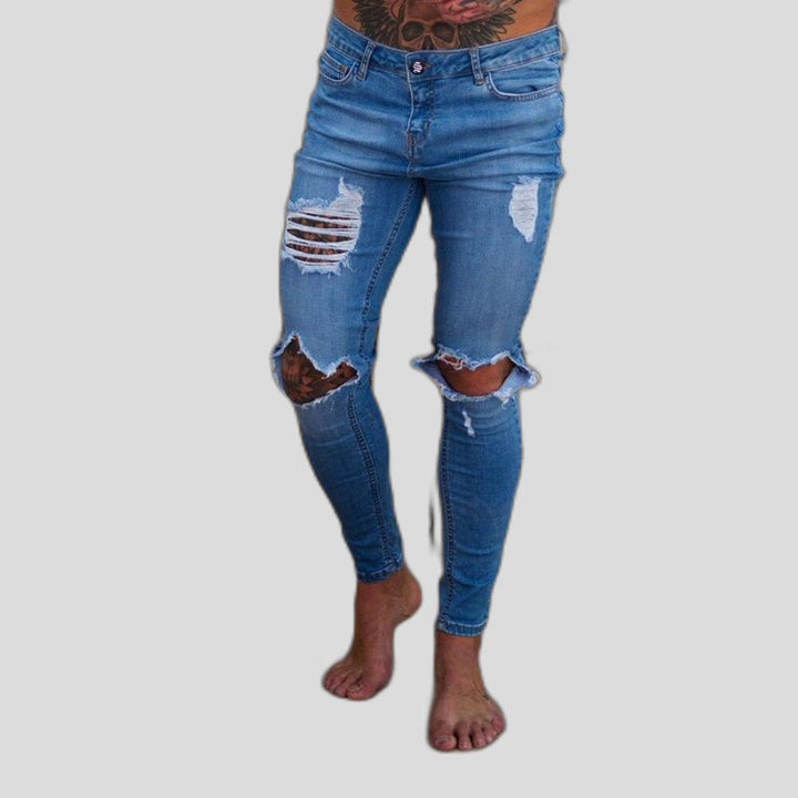 Męskie jeansy slim fit, charakteryzujące się modnymi dziurami i komfortowym krojem. Must-have w męskiej modzie.