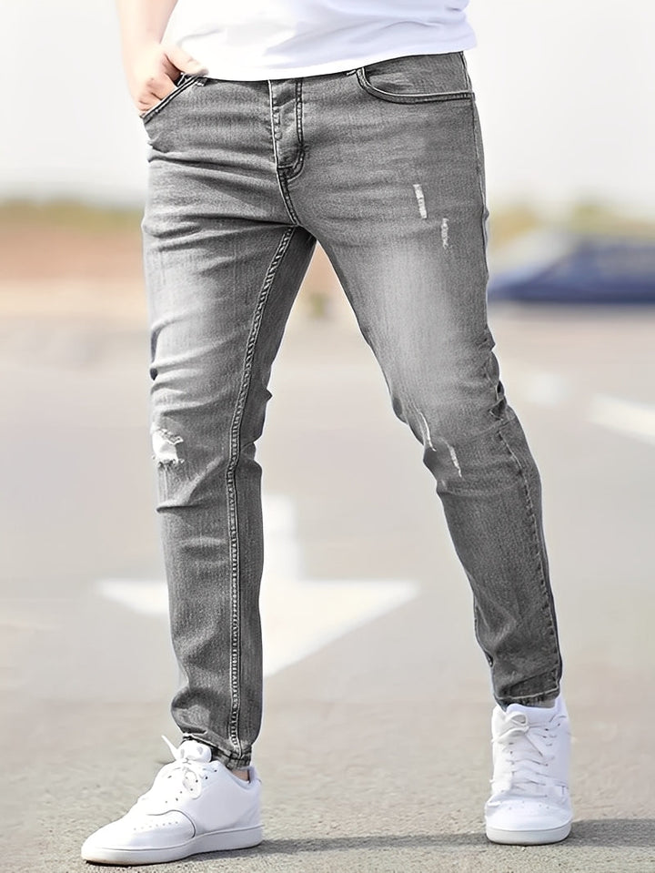 Męskie skinny jeans z modnymi przetarciami, idealne do miejskich stylizacji streetwear. Wygodny denim.
