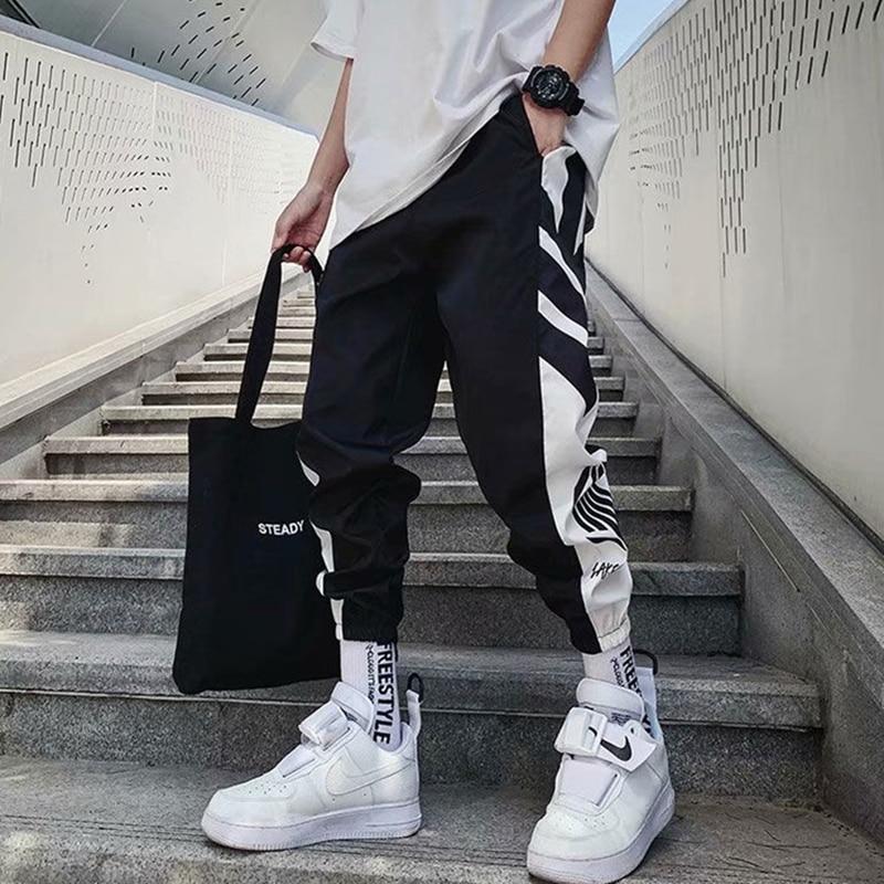 Czarne męskie spodnie dresowe z modnym nadrukiem, luźny krój, komfortowe, styl streetwear na co dzień.