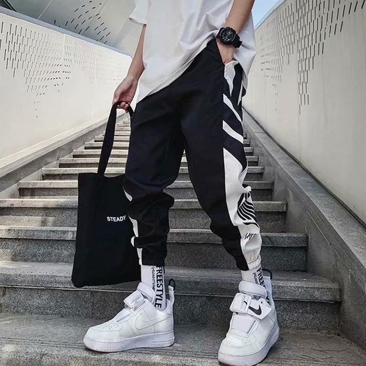Czarne męskie spodnie dresowe z modnym nadrukiem, luźny krój, komfortowe, styl streetwear na co dzień.