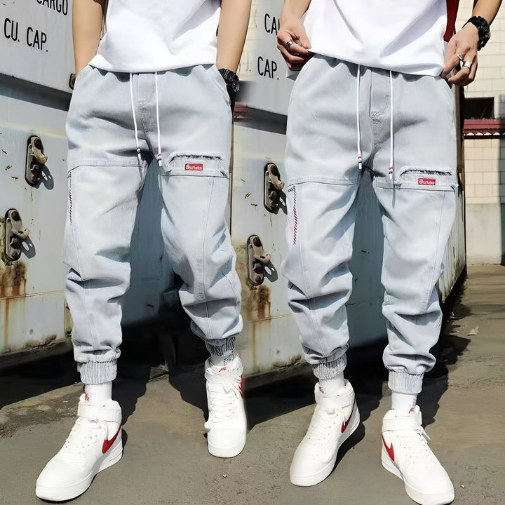 Czarne męskie baggy jeansy z elastycznymi mankietami. Modny luźny krój, idealny do streetwear i casualowych stylizacji.