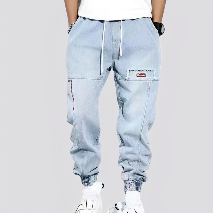 Niebieskie męskie baggy jeansy z mankietami, luźny krój. Komfortowe spodnie na co dzień, styl miejski, moda męska.