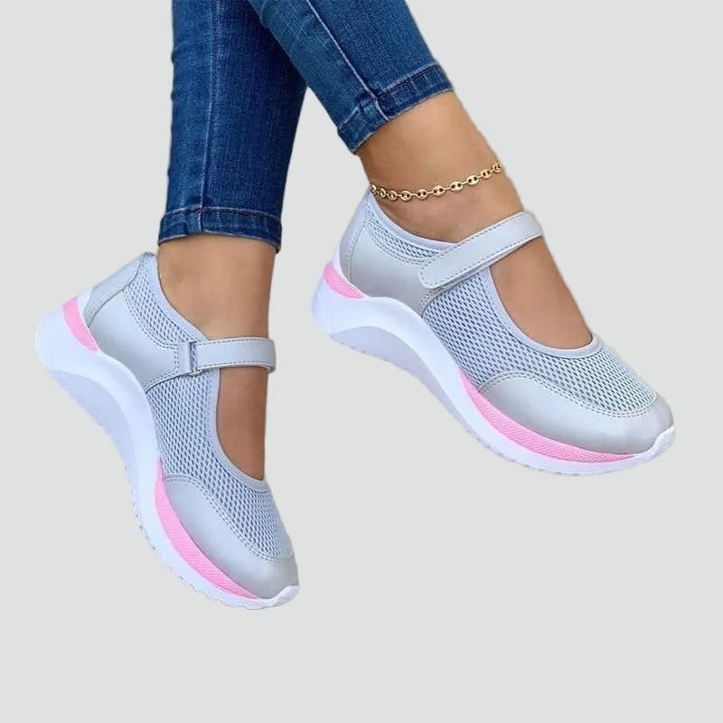 Szare damskie sneakersy z siateczki i paskiem na rzep prezentowane na stopie