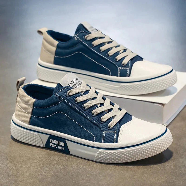 Męskie sneakersy w kolorze granatowym ustawione na jasnym tle