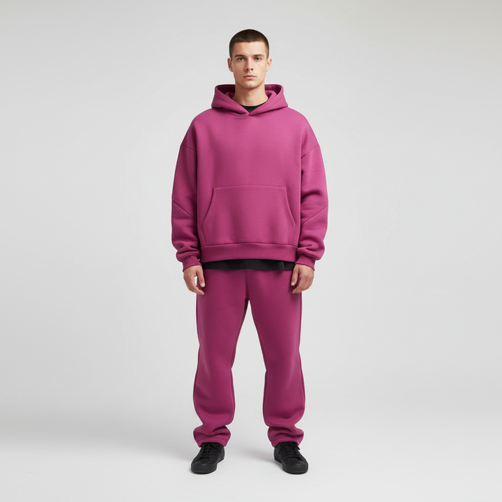Mężczyzna w różowym męskim dresie oversize z kapturem