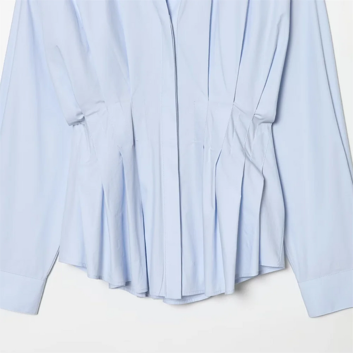 Niebieska minimalistyczna koszula damska z długim rękawem. Klasyczna, na guziki, idealna do eleganckich i casualowych looków.