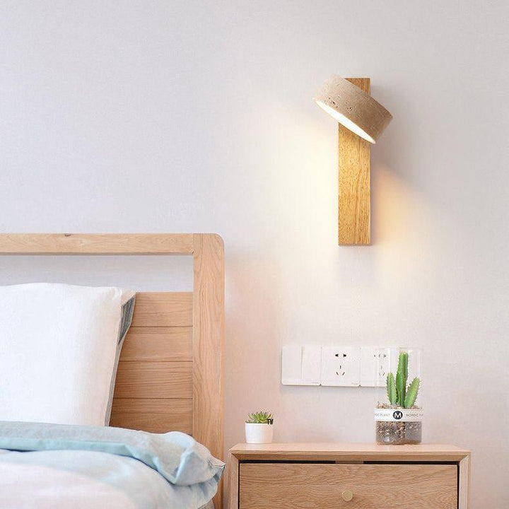 Lampa ścienna LED z trawertynu i drewna. Designerska forma, ciepłe światło dla przytulnej atmosfery w sypialni.