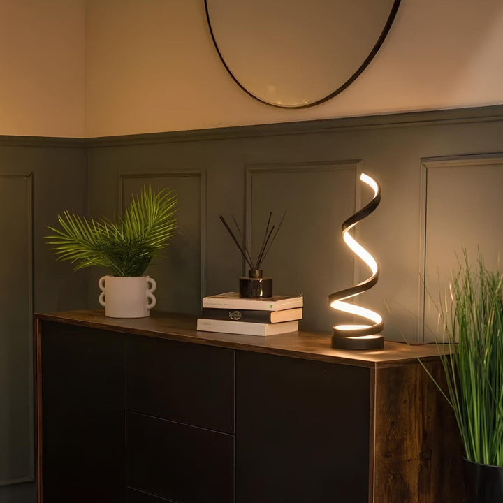 Biała, spiralna lampa stołowa LED na biurku. Nowoczesne oświetlenie do pracy lub czytania.