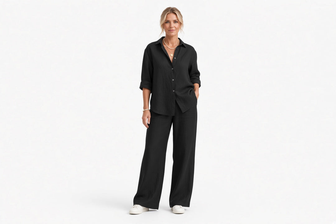 Kobieta w czarnym dwuczęściowym komplecie damskim stojąca w studiu
