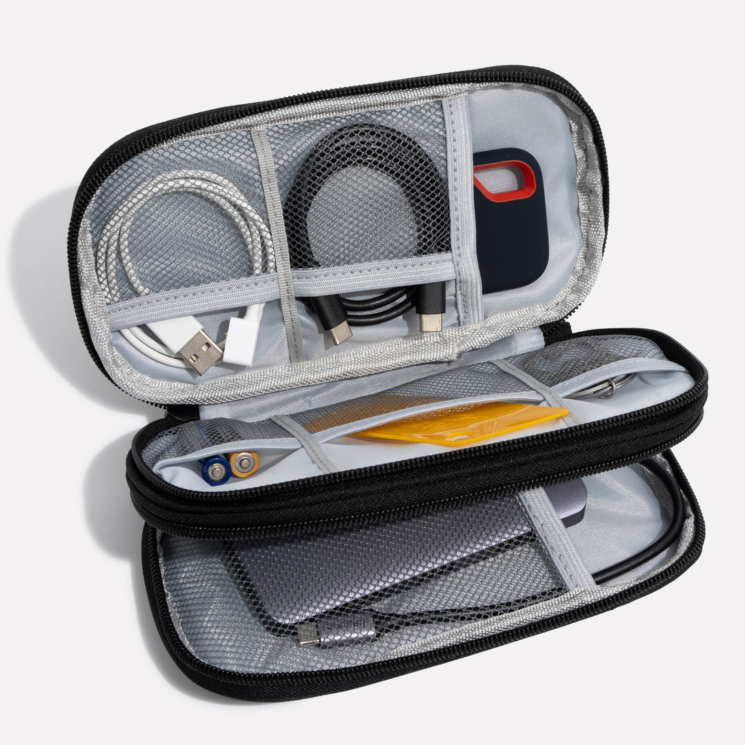 Wnętrze uniwersalnego organizera na elektronikę z przegródkami na kable, powerbank i adaptery do podróży.